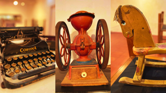 Objetos antiguos en exhibición: máquina de escribir, molino de semillas y caballo balancín de madera
